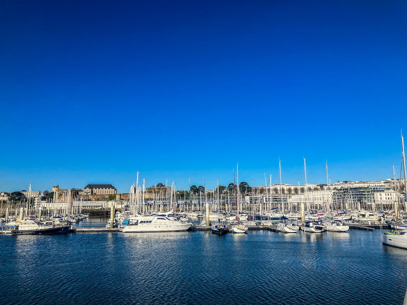 a harbor filled with lots of boats under a blue sky